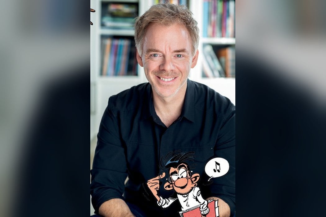 Portrait du dessinateur Delaf avec un dessin de Gaston