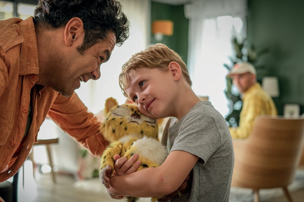 Scène du film Marsupilami, un homme et un enfant avec la peluche