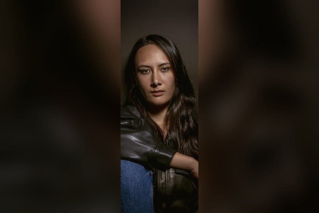 Meï Lepage assise, en veste de cuir