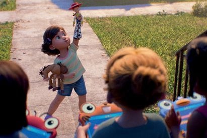 Une petite fille brandit Woody, scène de Toy Story 5