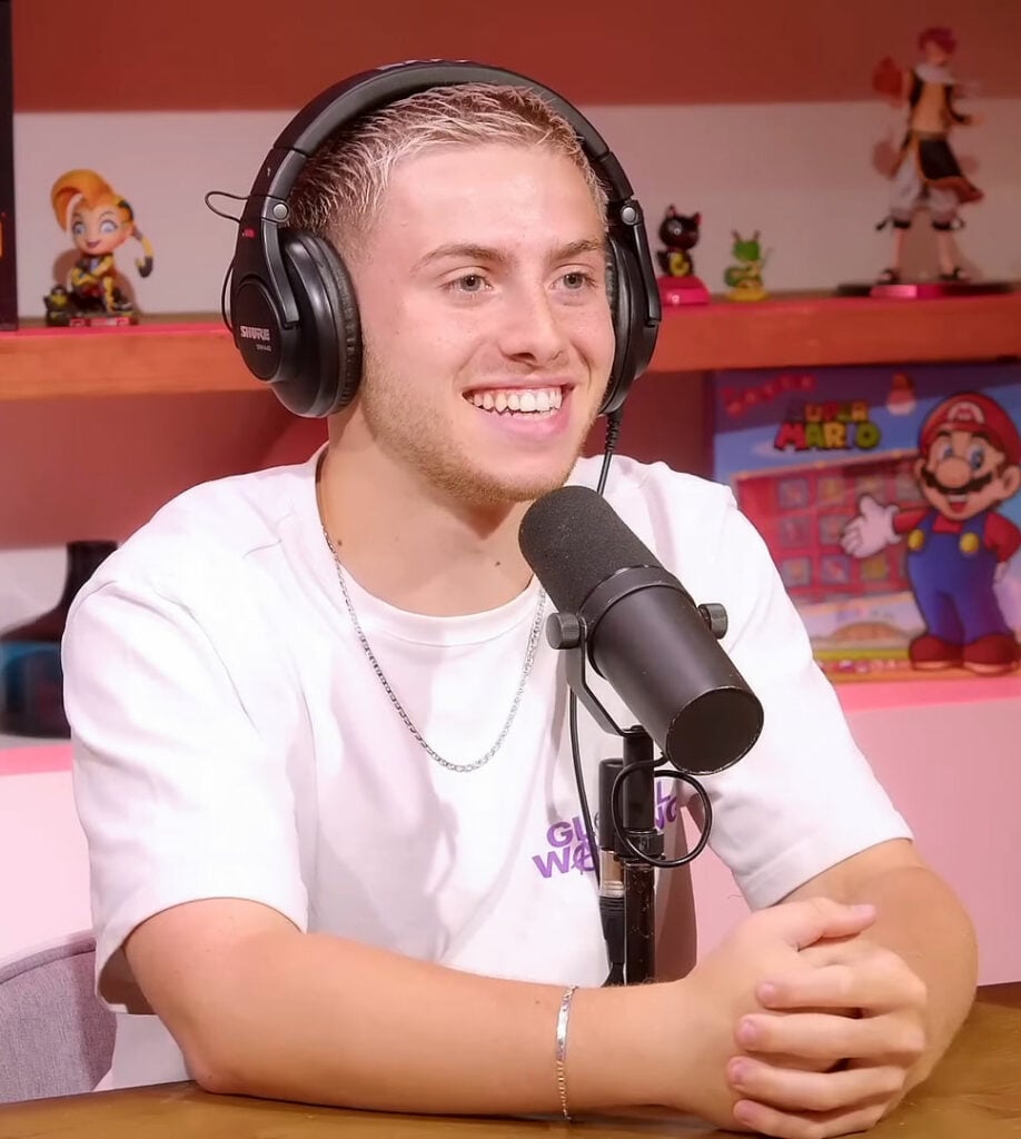 Le youtubeur Michou, casque sur les oreilles, en interview face à un micro, en 2023